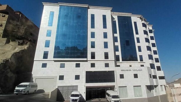 Ein mehrstöckiges Gebäude mit modernem Design, große Fenster und eine glatte Fassade.