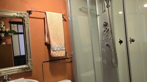 A bathroom with a glass-enclosed shower, a sink, and a toilet. - El Paisaje cuencano, 1 dorm. 2 camas, en el centro historico con una linda vista (Cuenca)