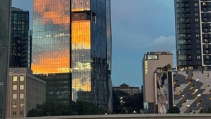 Un gratacels modern amb el logotip d'Invesco, envoltat d'altres edificis.