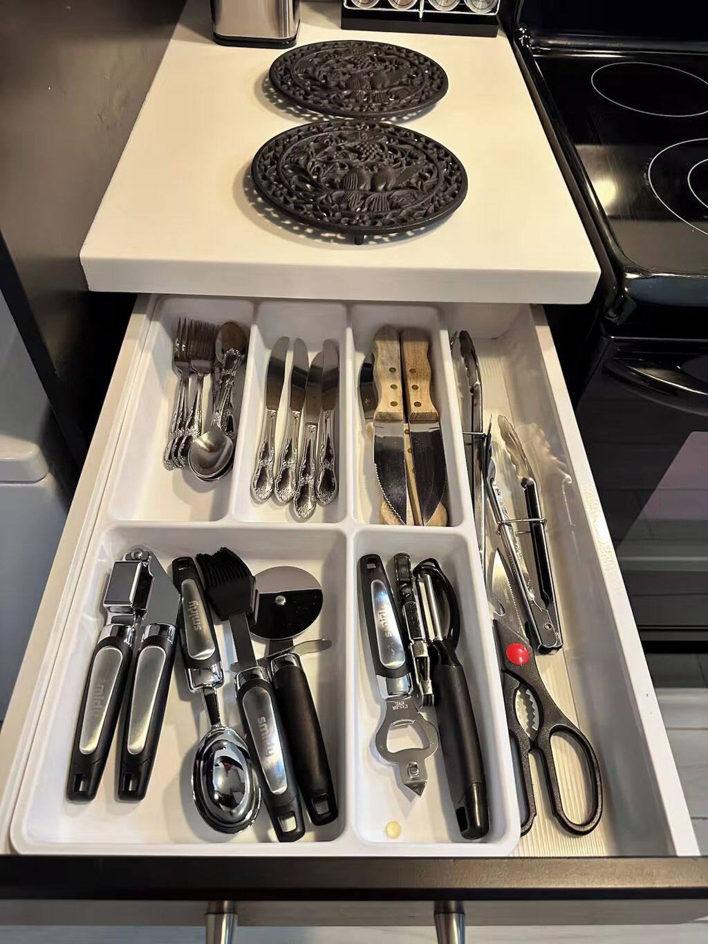 A kitchen drawer with utensils and cookware.
