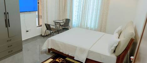 Un dormitorio con cama, escritorio y televisor que muestra 'No Signal'.