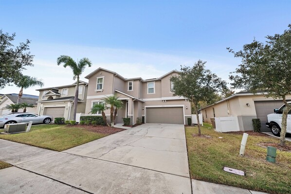 A residential area with houses, a driveway, and a parked car. - 8BR house with private pool in Crystal Cove (Kissimmee)