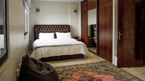 Une chambre avec un grand lit, une armoire et un miroir.