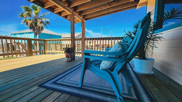 A wooden deck with a blue chair and a potted plant.