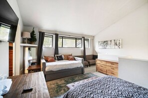 Un dormitorio moderno con una cama grande, un escritorio, una silla y un armario.