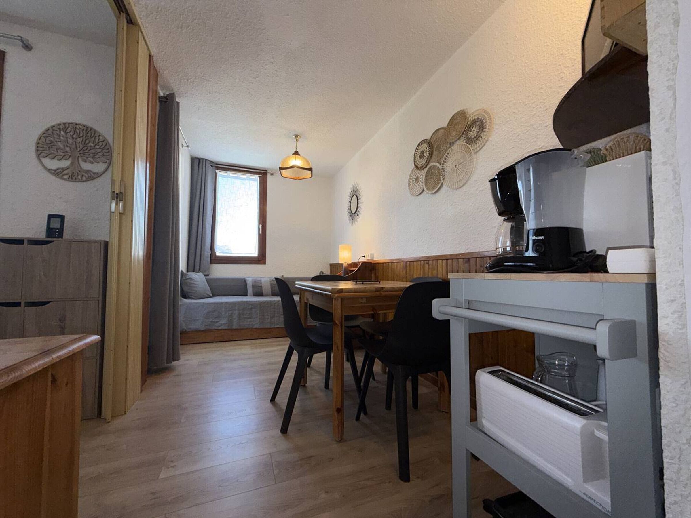 Eine kompakte Küche mit Essbereich, Holzmöbeln und einer Kaffeemaschine.