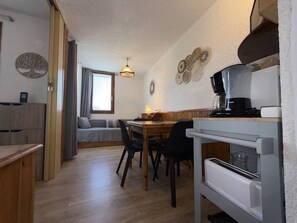 A compact kitchen with a dining area, wooden furniture, and a coffee machine. - Studio 4 people, near slopes, pets allowed, Wifi (Valmorel)