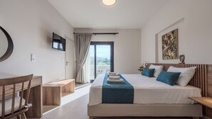 Un dormitorio moderno con una cama grande, un escritorio y un televisor.