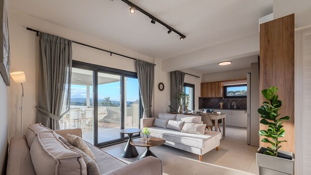Una sala moderna con sofá, mesa de centro y vistas al exterior.