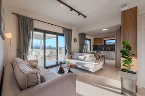 Un salon moderne avec un canapé, une table basse et une vue sur l’extérieur.