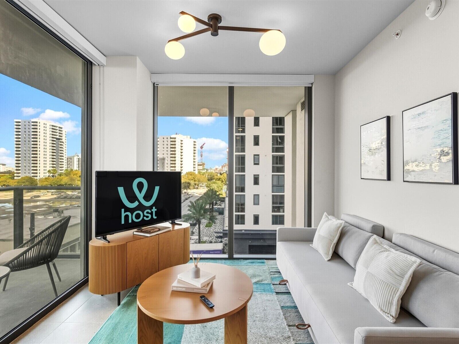 Uma sala de estar moderna com um sofá, uma mesa de centro e uma TV exibindo o logotipo 'host'.
