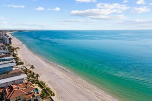 Ein Küstenhotel mit Blick auf den Strand, mit einem langen Sandstrand und dem Meer.