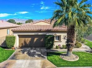 A residential house with a garage, a palm tree, and a well-maintained lawn. - Gorgeous house with private pool/hot tub in a gated community in Bermuda Dunes. (Bermuda Dunes)