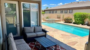 A patio with a pool, outdoor furniture, and a stone floor. - Gorgeous house with private pool/hot tub in a gated community in Bermuda Dunes. (Bermuda Dunes)