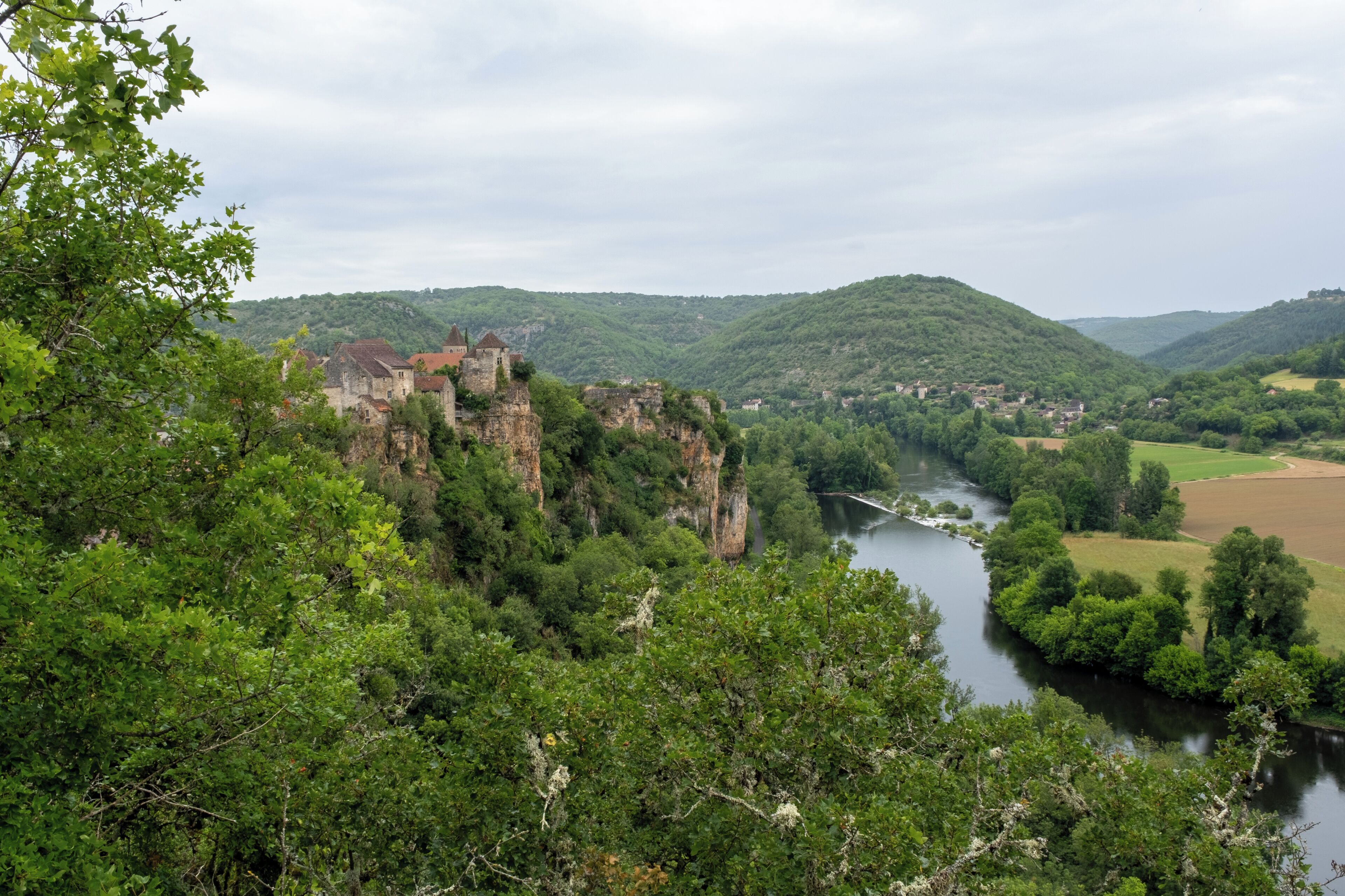 A castle on a cliff overlooking a river and valley.