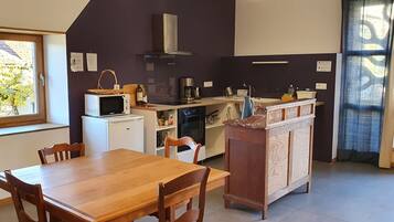 A compact kitchen with a microwave, coffee maker, and a wooden cabinet.