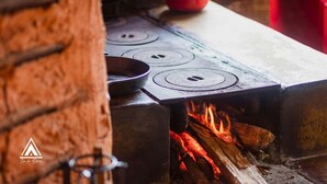 A traditional wood-fired stove with three burners and a pot on top. - Chalé Tipi da Serra (Brumadinho)