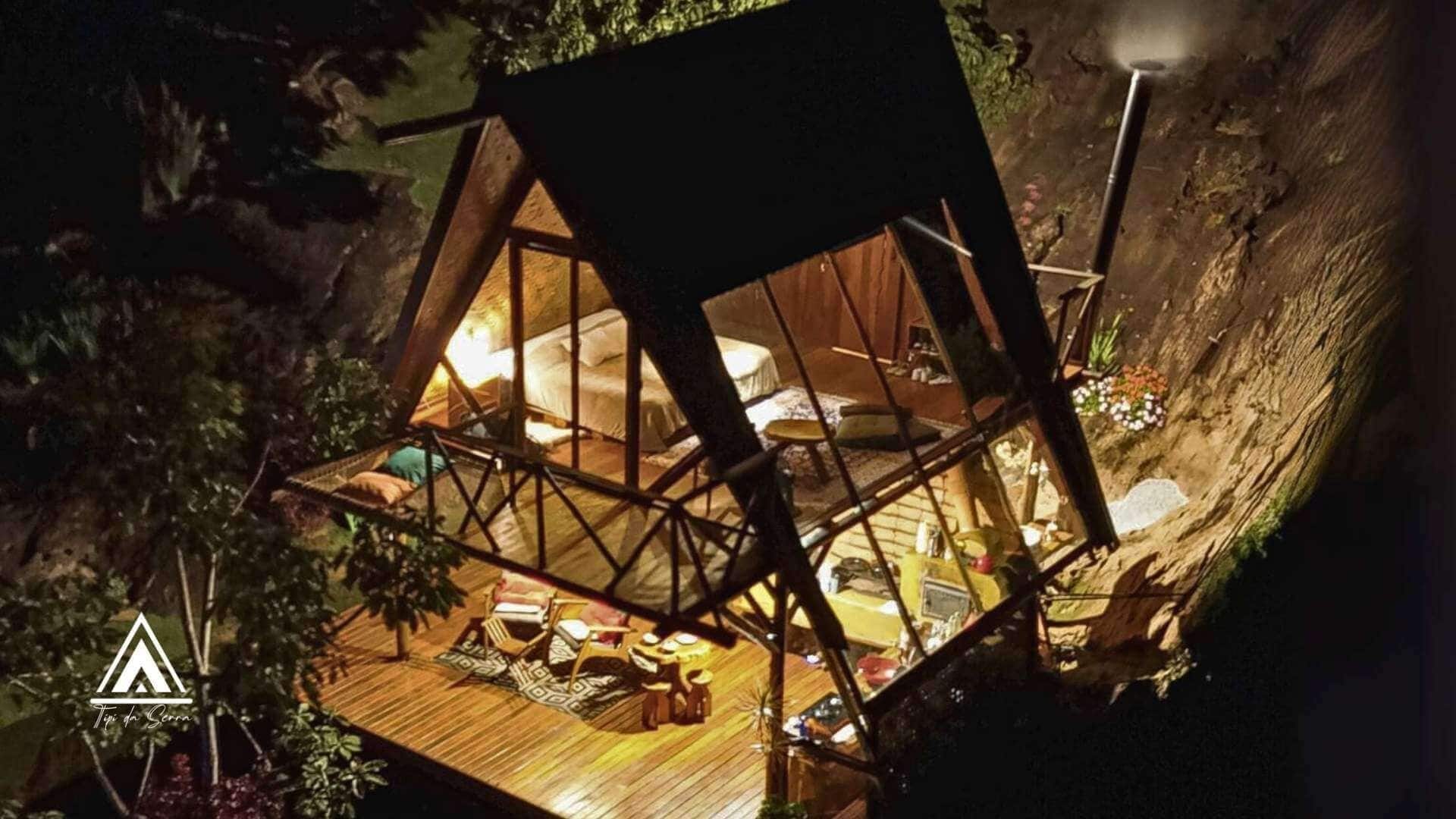 A treehouse with a wooden floor, a bed, and a small table.