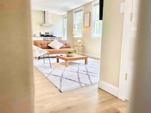 Uma sala de estar moderna com sofá, mesa de centro e tapete.