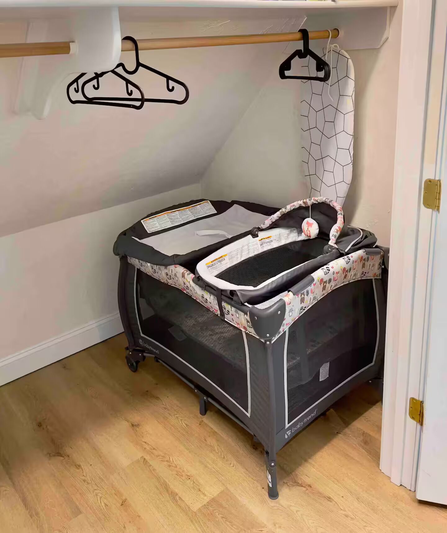 A baby gym with a black frame, a mesh play area, and a patterned canopy.