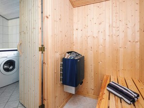 A small laundry room with a washing machine, a blue storage unit, and a wooden bench. - 6 Person Holiday Home in Hemmet (Hemmet)