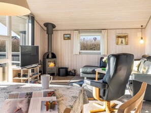 A cozy living room with a fireplace, leather sofa, and a television. - 6 Person Holiday Home in Hemmet (Hemmet)