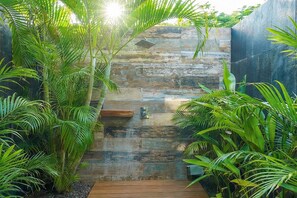 A wooden deck leading to a stone wall with a hanging light fixture. - Premium Location Gated Beach Community Villa (Tamarindo)