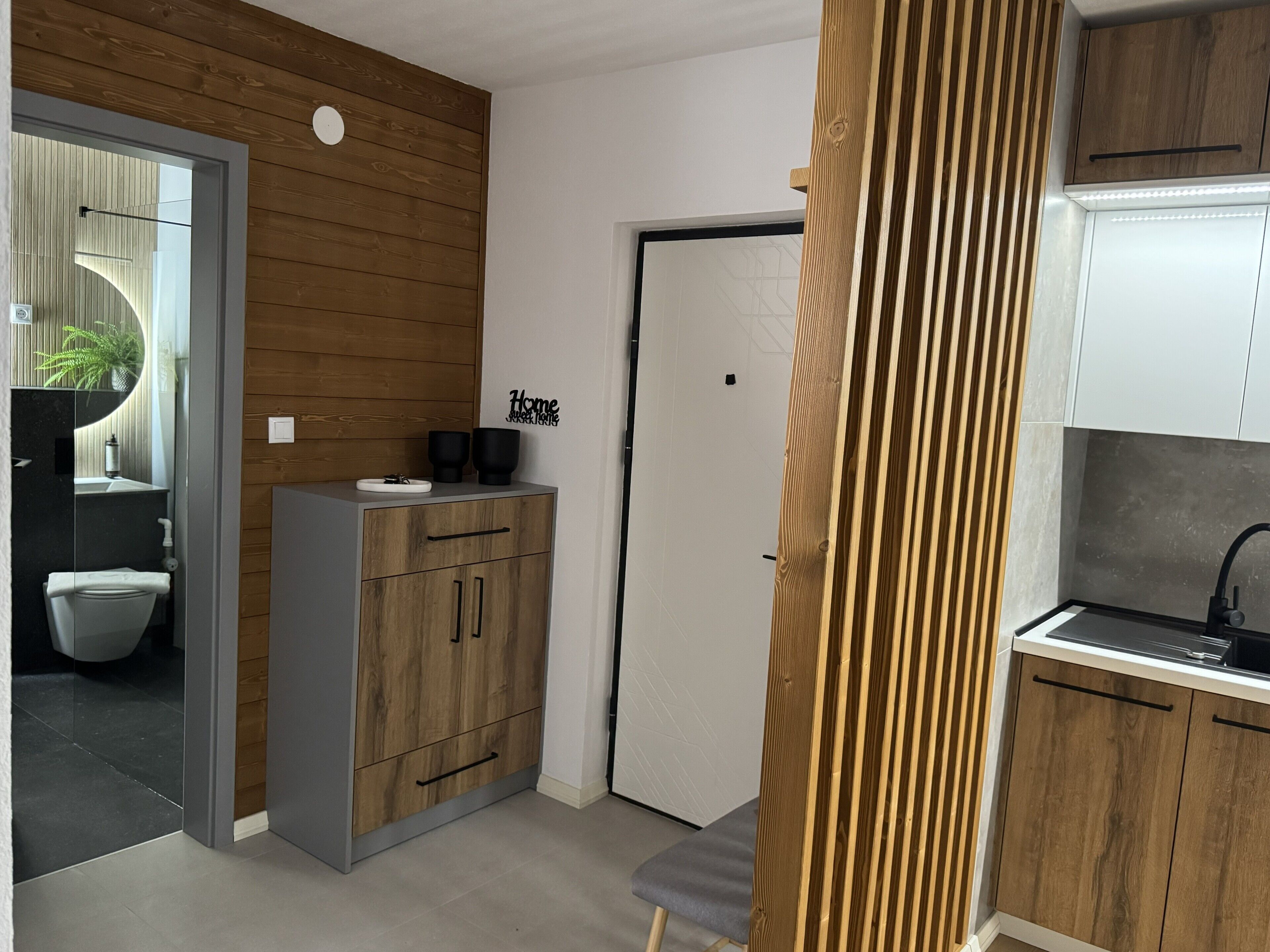 Une cuisine moderne avec des meubles en bois, un four encastré et un évier.