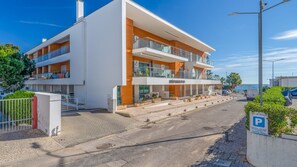 A modern multi-story hotel with balconies, a parking area, and a view of the sea. - T2 Luminoso c/Piscina perto da Praia by LovelyStay (Olhos de Água)