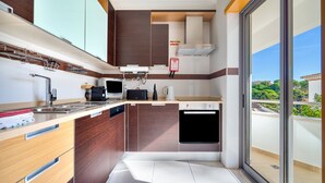 A modern kitchen with a built-in oven, microwave, and coffee maker. - T2 Luminoso c/Piscina perto da Praia by LovelyStay (Olhos de Água)