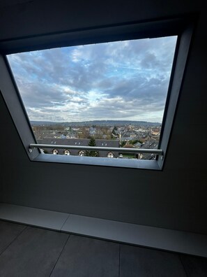 A skylight window with a view of a cityscape. - Cosy nest in pont l'évêque (pont l eveque)
