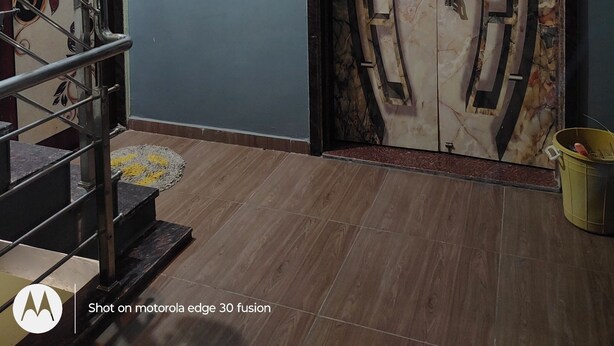 A room with a marble door, a chandelier, a framed picture, and a staircase. - MAHAKALI HOMESTAY (Garudeshwar)