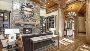 A spacious library with a fireplace, bookshelves, and a cozy seating area. - 3bd 4ba Ski in Ski Out w/ Lift Tickets Included! (Avon)