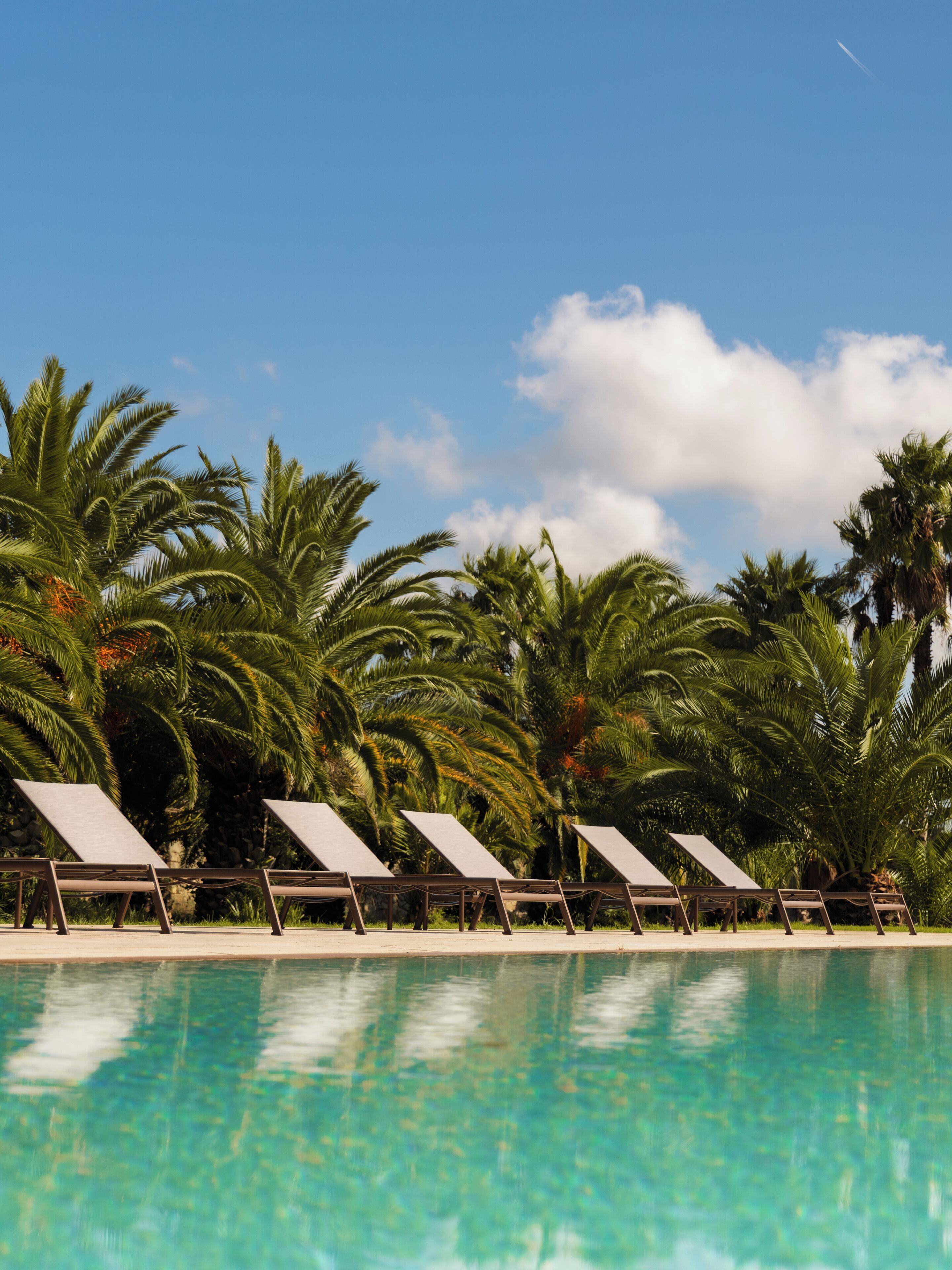 Una piscina al aire libre de temporada, sombrillas