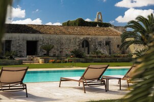 Una piscina al aire libre de temporada, sombrillas, tumbonas