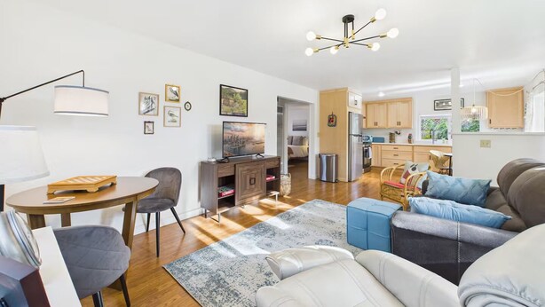 A modern living room with a television, seating, and a dining area. - Garden Casita-Walk to Town (Arcata)