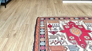A room with a wooden floor, a blue door, a grey wardrobe, and a patterned rug. - Colosseum Apartment 23 (Roma)