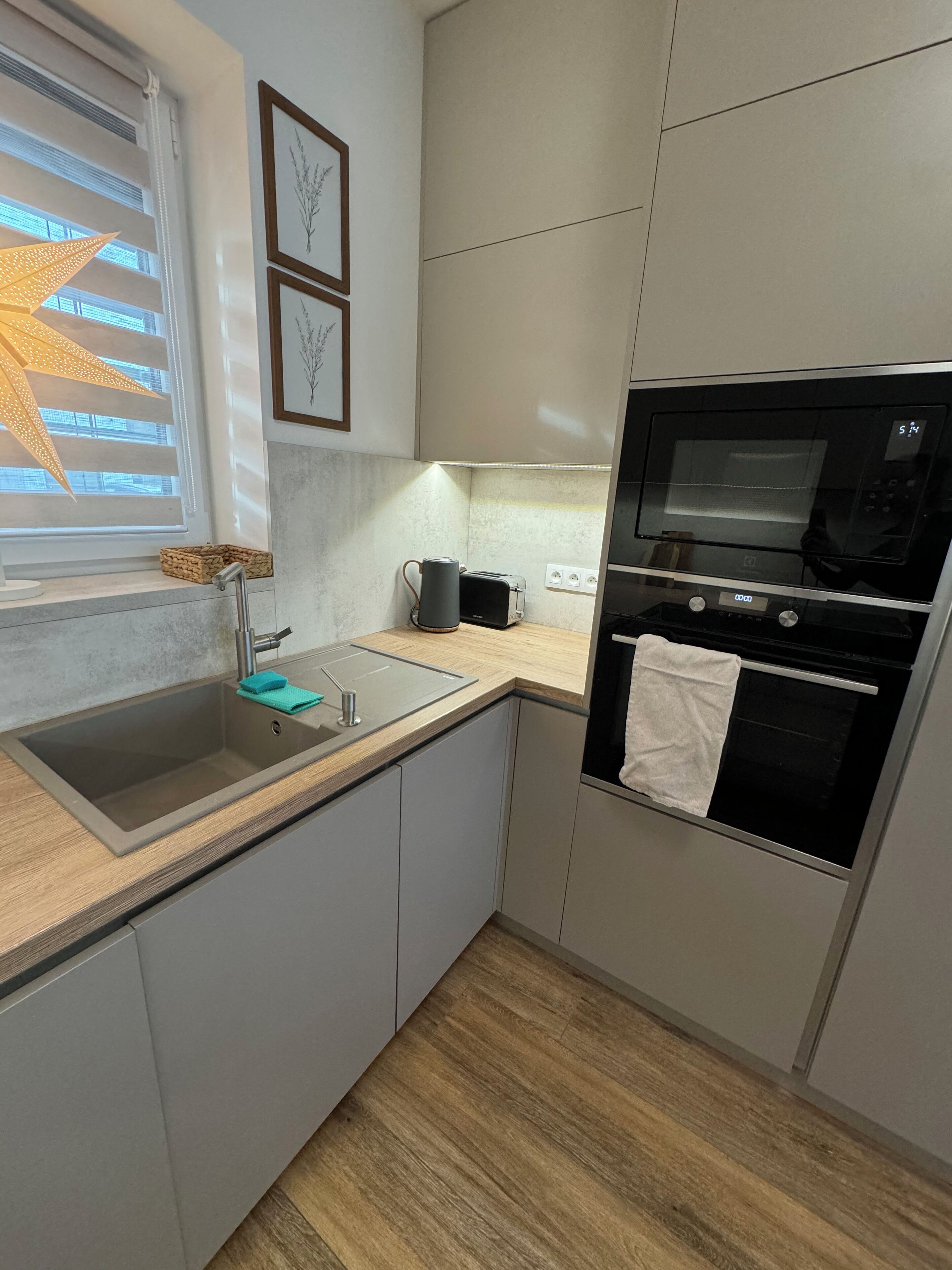Una cocina moderna con un lavamanos, encimera y horno empotrado.
