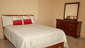 Ein Schlafzimmer mit einem Bett, einem Schminktisch und einem Spiegel.