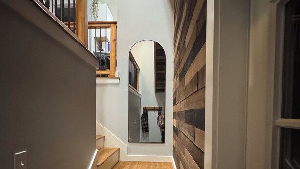 A staircase with wooden steps and a modern design, leading to a second floor with a wooden railing and a view of the interior. - Contemporary Countryside Home, Minutes to Concord (Loudon)