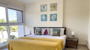 Un dormitorio con cama, mesita de noche, ventana y decoración en la pared.