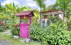 A tropical resort with a pink gate labeled 'Tres Pipas Beach House Bungalows'. - Tres Pipas-Selva | Beachfront Arrecife, Wifi, AC (Punta Uva)