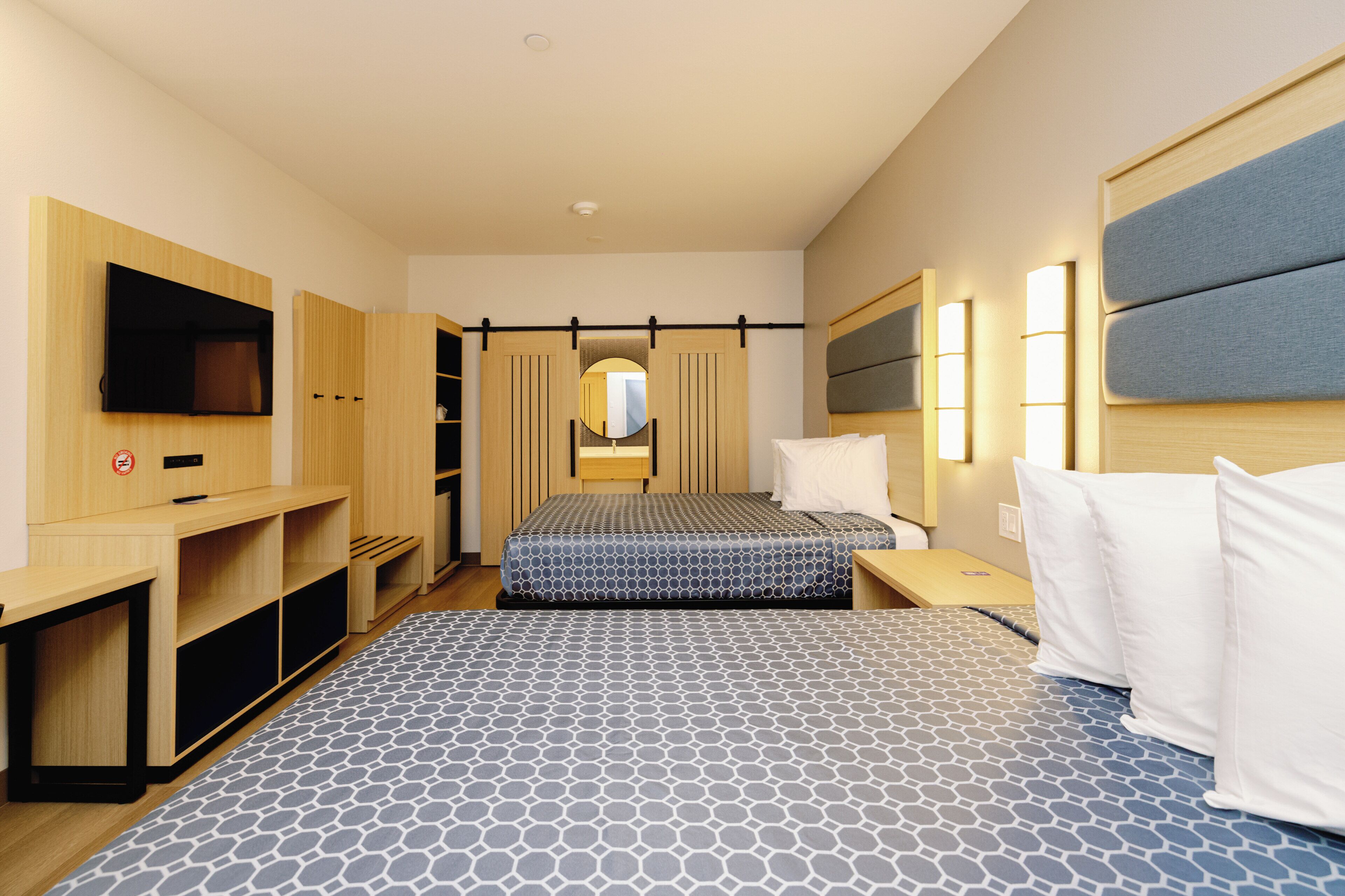 Een hotelkamer met een bed, een televisie, een bureau en een kledingkast.