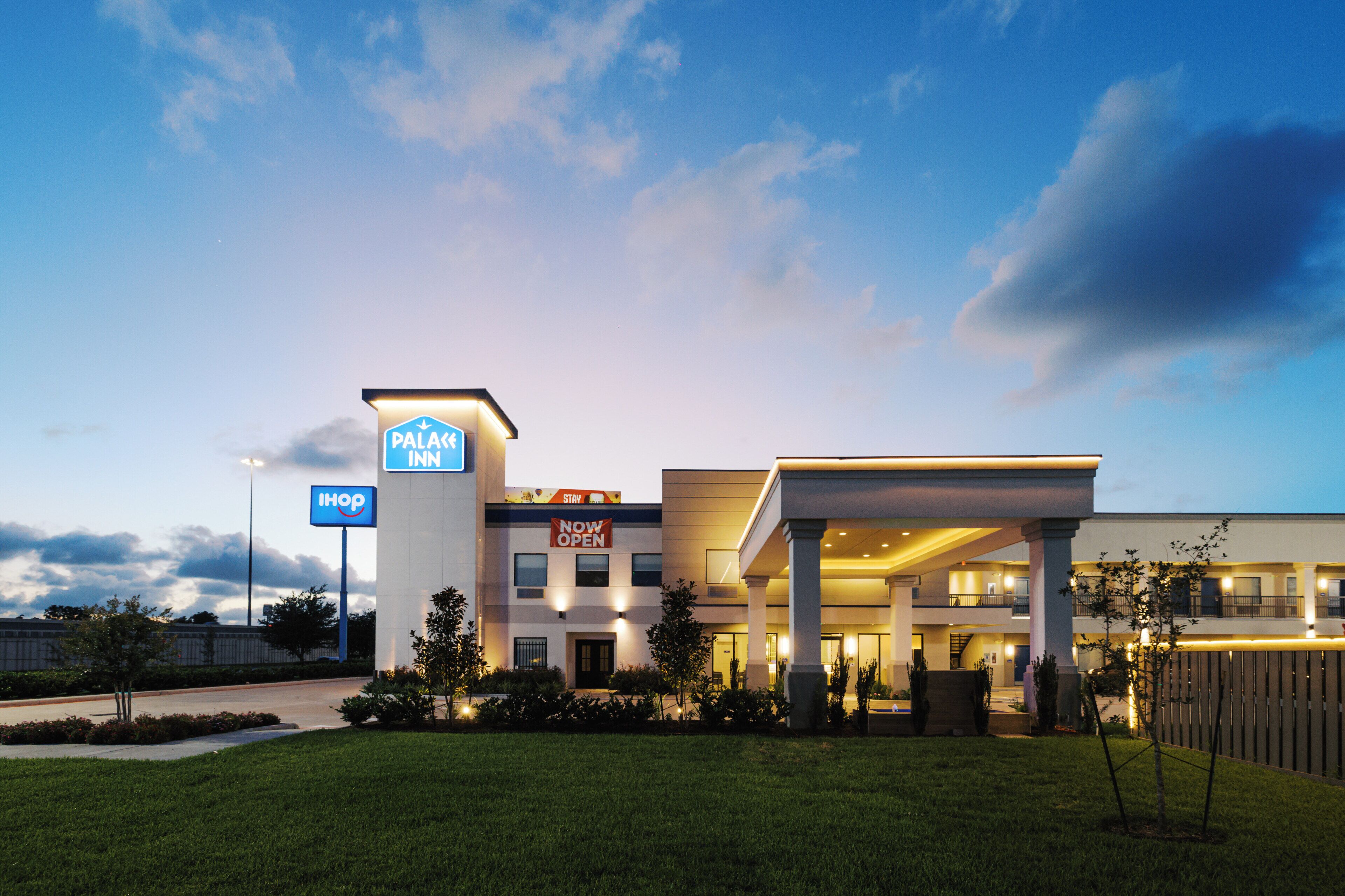 A hotel with a sign indicating it's a 'Palace Inn' and 'Now Open'.