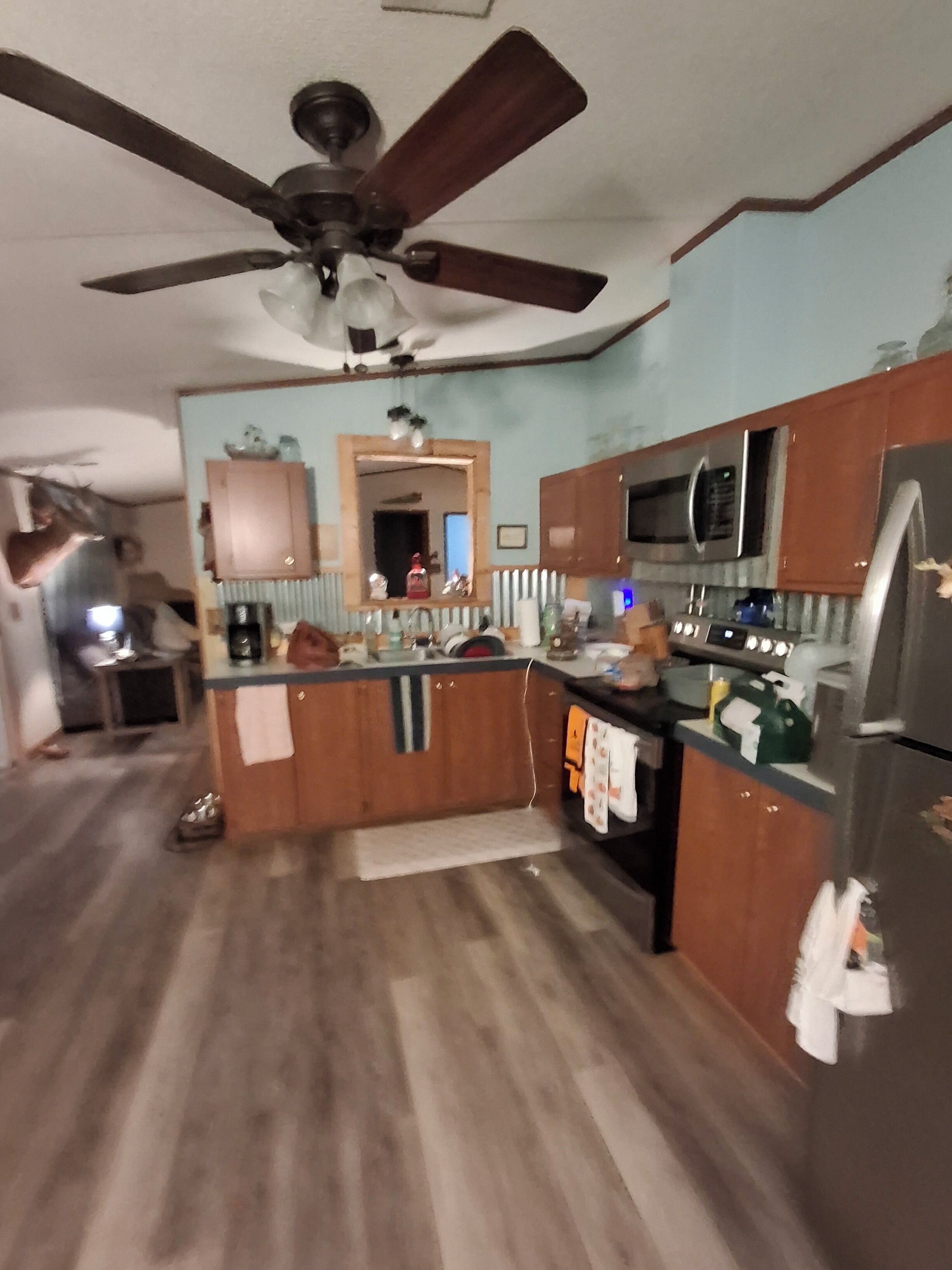 A kitchen with wooden cabinets, a microwave, and a refrigerator.