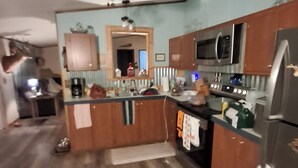A kitchen with wooden cabinets, a microwave, and a refrigerator.