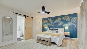A bedroom with a bed, a ceiling fan, a nightstand, and a wall with a palm tree mural. - Houston white house, private pool, patio and game room the best place in Houston (Houston)