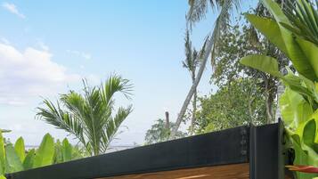 Un área de spa con dos camillas de masaje, una valla de bambú y abundante vegetación tropical.