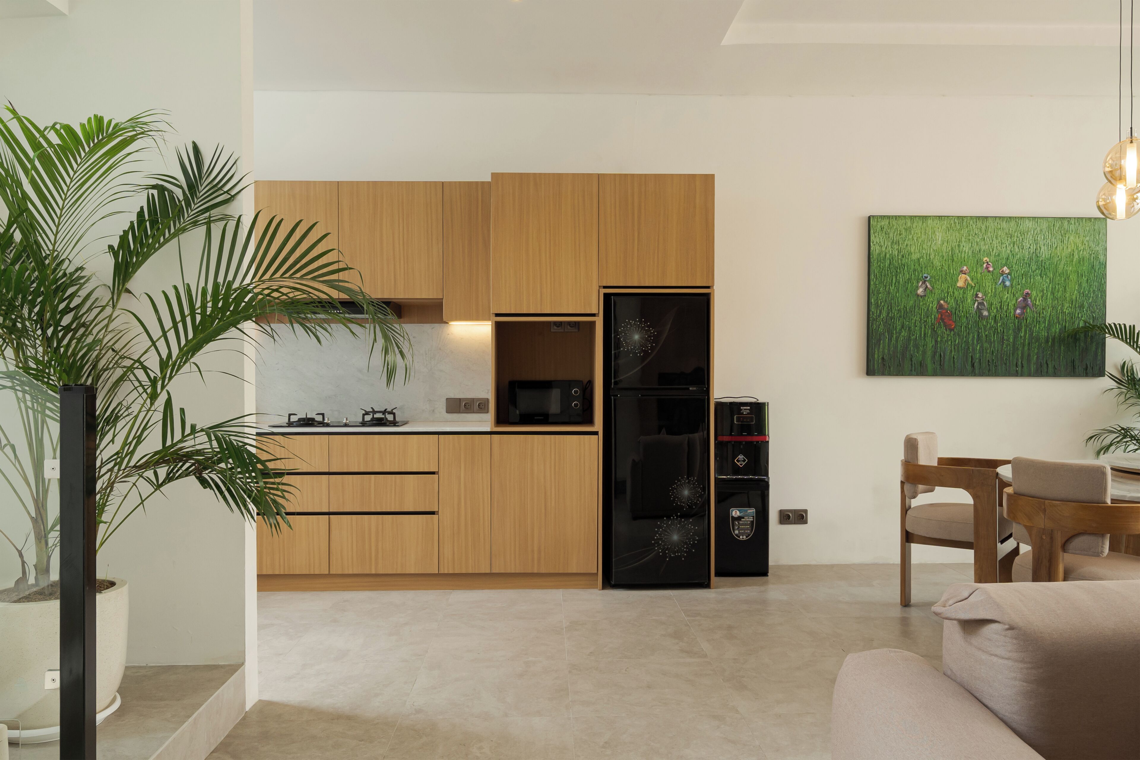 A modern kitchen with wooden cabinets, a black refrigerator, and a microwave.