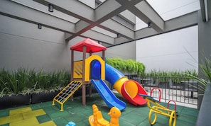 An outdoor play area with a slide, climbing net, and a small yellow duck toy. - Apt w/ BBQ & Balcony 220 m From the Beach Rty0216 (Florianópolis)